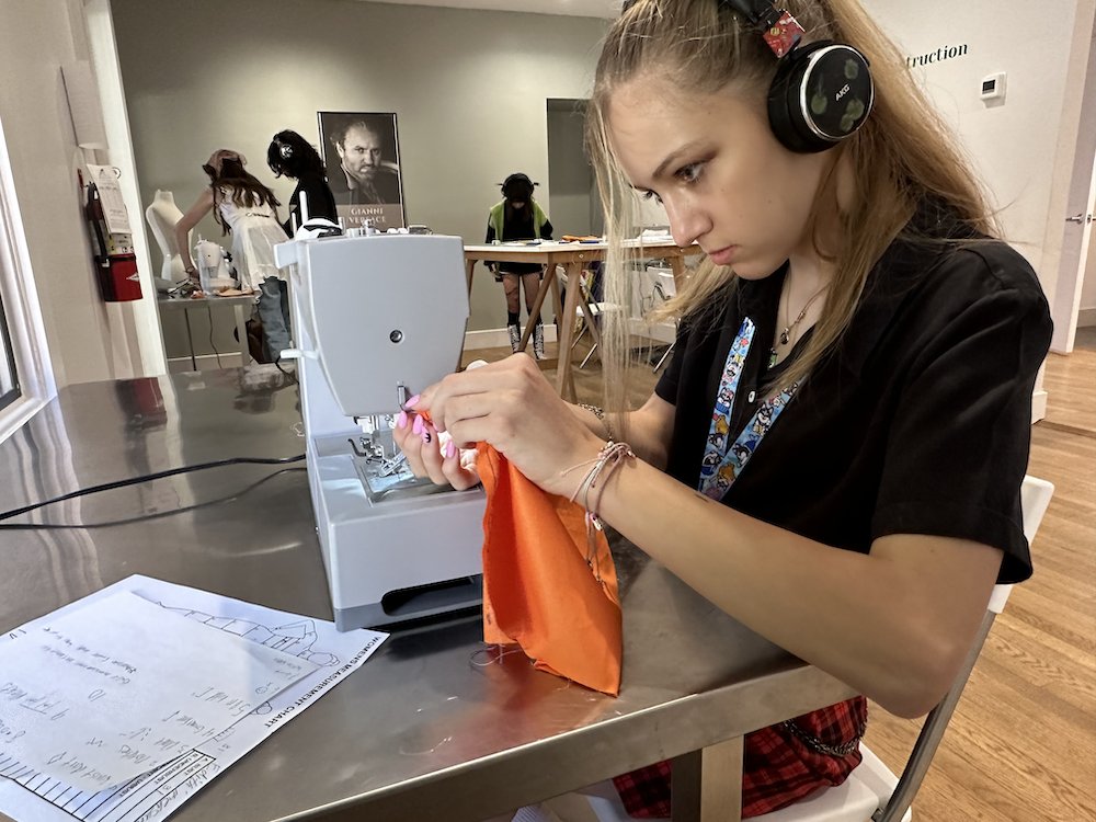 The Garment League youth participant sewing